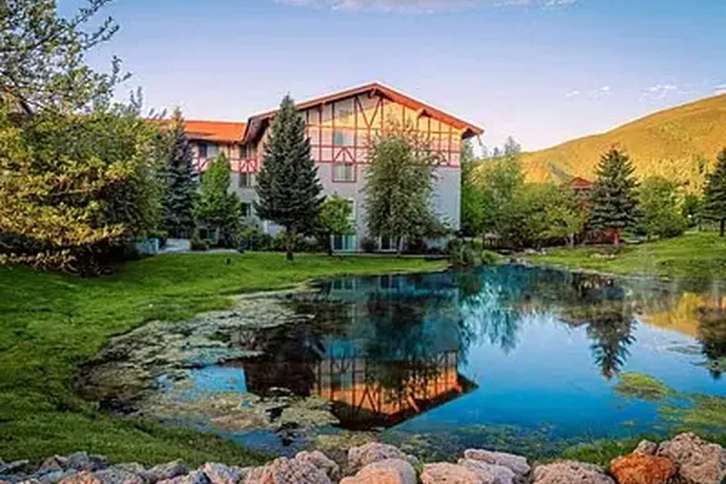 Lodge-style home reflected in a pond on a summer evening in Wallsburg, Utah, a house cleaners service area