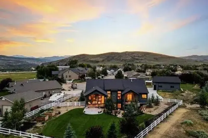 Aerial view of a modern home with white fenced yard at sunset in Francis, Utah, served by our house cleaning team